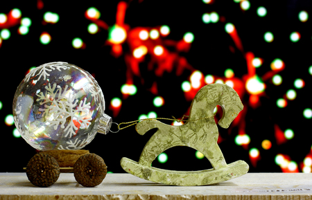 Christmas and New Year`s background with glass balls in child craft truck and decoupage horse hand made toys. Colorful holiday bokeh garland lights. Copyspace concept congratulations card.の写真素材