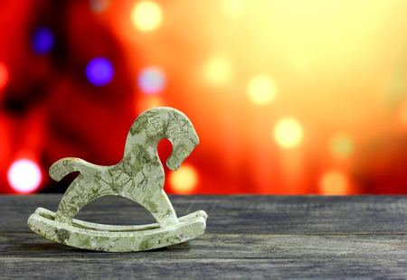 Christmas and New Year`s background with decoupage horse hand made toys. Colorful holiday bokeh garland lights. Yellow copyspace in top corner. Concept congratulations card.の写真素材