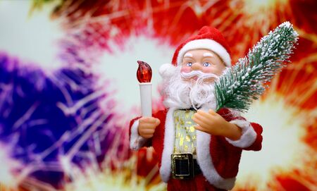 New Year`s card with Père Noël toy brings Christmas tree at glow bokeh background in the colors of the French flag. Big Copyspace concept for market banner, poster, congratulations.の写真素材