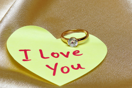 Marriage proposal card. Ring with diamond and inscription I love you on valentine heart from paper.の写真素材
