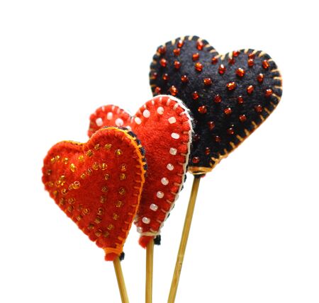 Decorative hand made hearts isolated on white background. Sewed from a felt and decorated with beads. Beautiful congratulation card background for St. Valentine`s day. Copyspace.の写真素材
