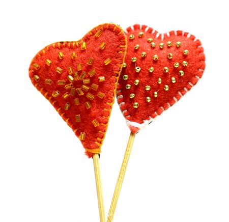 Decorative hand made two hearts isolated on white background. Sewed from a felt and decorated with beads. Beautiful congratulation card background for St. Valentine`s day. Copyspace.の写真素材