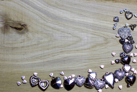 Corner frame border of Hearts beads on wooden background. Love card for Valentine's day. Concept with big copyspase for hand made crafts or DIY illustration.の写真素材