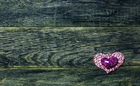 Shine plastic hearts on old dark  wooden background. Love card for Valentine's day. Concept with big copyspase for hand crafts or DIY illustration.の写真素材