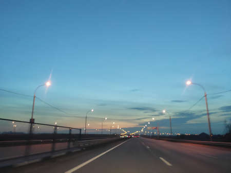 Sunset and sky, road running into the distance and evening lights