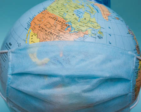 protective medical mask on a globe close-upの写真素材