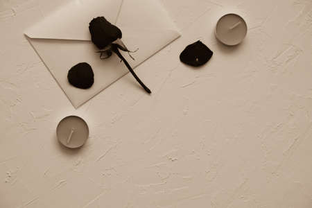 white envelope, dry rose and red candles on a white textured backgroundの写真素材