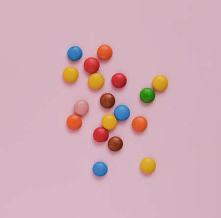 assorted multicolored sweets dragee on a pink background