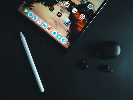 Malaysia, Shah Alam, June 20, 2020: IPad air 3 releases from Apple company, release of this ipad model in 2019. Pair of black realme wireless earbuds with iPad.のeditorial素材