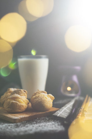 Selective focus of cream puff and milk on the table with a light bokeh effect.