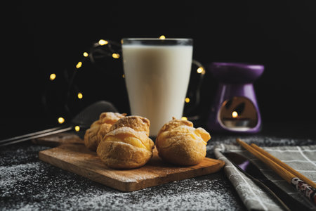 Selective focus of cream puff and milk on the table with a light bokeh effect.の写真素材
