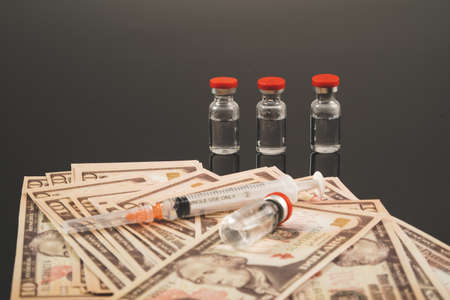 Close up Vaccines, syringe and money on the tableの写真素材