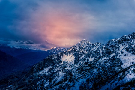 Colorful and dramatic sky above rugged mountains at dusk at a sky resort near Sochi, Russia.の写真素材