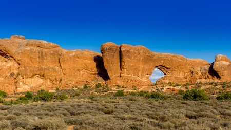 Sandstone arch at Arches National Park in Utah with brilliant blue sky.の写真素材