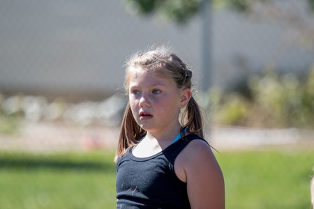 Cute young girl with pigtails playing outside on a sunny day and blurred background.の写真素材