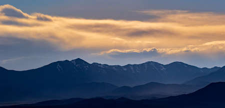 Golden mountain landscape panorama at sunset or sunrise and wispy cloudsの写真素材