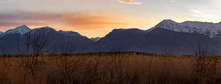 Stunning panorama of grass in the foreground and the Rocky Mountains in the background at sunsetの写真素材