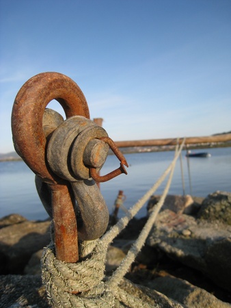 Close-up of a rusty metal dock where a boat is anchored.の写真素材