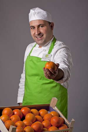 Fruit seller offering an orangeの写真素材