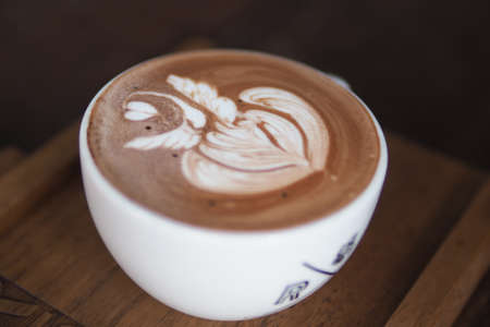 hot white coffe cup on the wooden table
