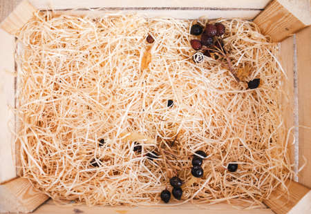 Box with wood shavings and some dried rose.