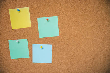 Coloreful sheets of note papers on wooden background.