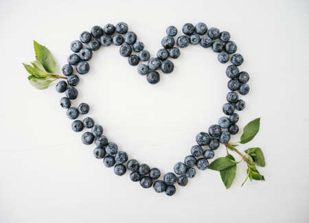 Love heart shape made of blueberries on bright background.の写真素材