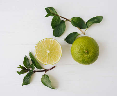 Fresh green lime and mint leafs on white background.の写真素材
