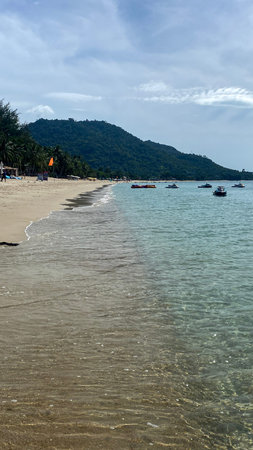 Beautiful tropical beach with transparent sea water, sandy coast and green mountains in the...