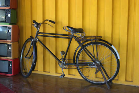 Ancient bicycle and retro television with yellow background.の写真素材