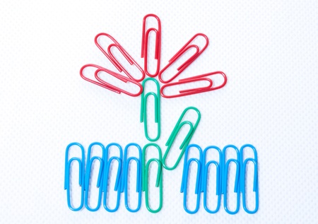 the red flower with color paper clips on the white background