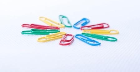 Color paper clips on the white background
