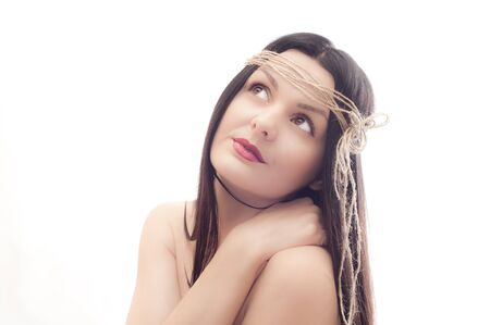 Portrait of the beautiful young girl with an old rope on a head on a white backgroundの写真素材