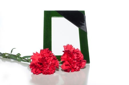 green photo frame with a mourning black tape and red carnations on a light backgroundの写真素材