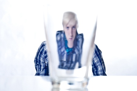 the serious stylish young man looks through glass