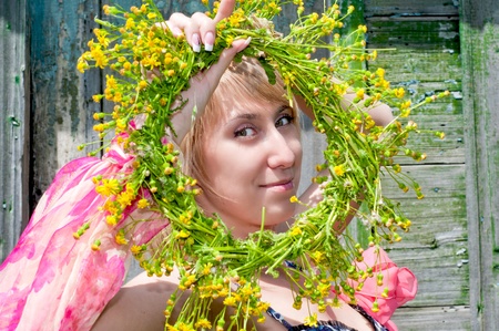 the beautiful girl with a wreath from wild flowers in handsの写真素材