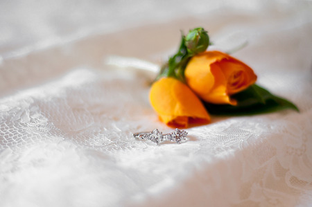 buttonhole of the groom and earring of the bride on a wedding dress