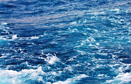 Water waves and splashes behind moving boat