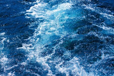 Water waves and splashes behind moving boat