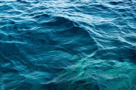 Dark Blue water waves under the midday Sun