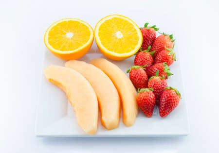 Mix fruits in white plate,melon,strawberry,orangeの写真素材