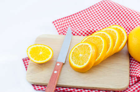 slice of orange with knife and wooden boardの写真素材