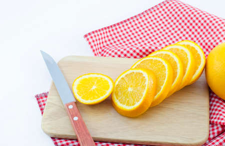 slice of orange with knife and wooden boardの写真素材