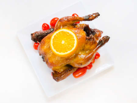 Roasted chicken and sliced orange,cherry tomatoesの写真素材