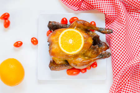 Roasted chicken and sliced orange,cherry tomatoesの写真素材