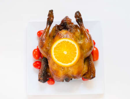Roasted chicken and sliced orange,cherry tomatos with place for your textの写真素材