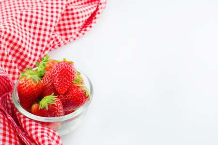 Red napkin and strawberry on white background with place for textの写真素材