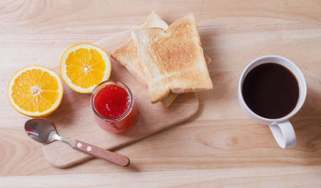 Breakfast with Coffee toasts and strawberry jam on wooden tableの写真素材