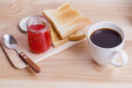 Breakfast with Coffee toasts and strawberry jam on wooden tableの写真素材