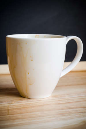 Coffee mug with stains on woodden tableの写真素材
